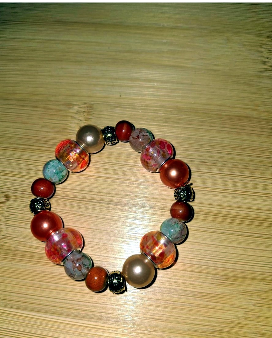 Peachy Orange Bracelet: Multi-colored peachy orange bracelet featuring resin, glass, and metal beads.