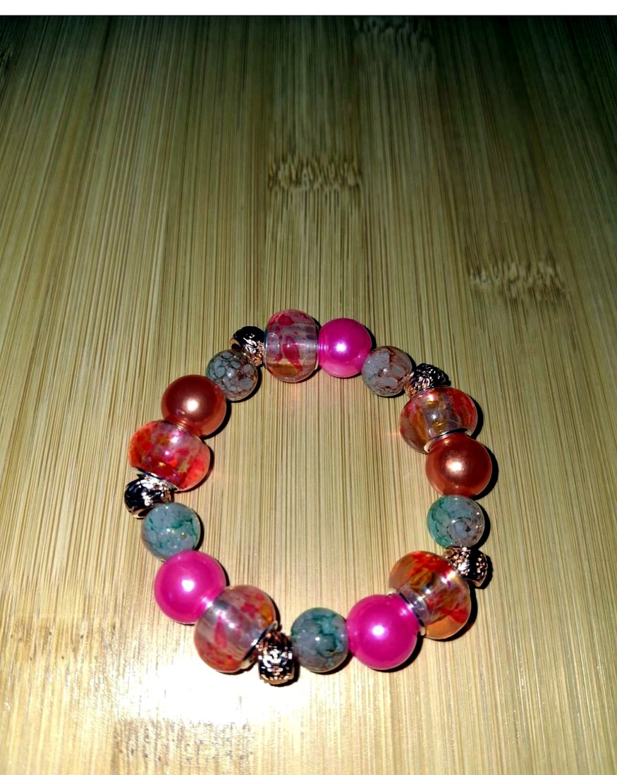 Pink & Orange Bracelet: Pink and orange bracelet featuring resin, glass, and metal beads.